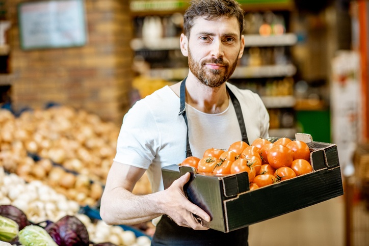 Worker with vegetables in the supermarket