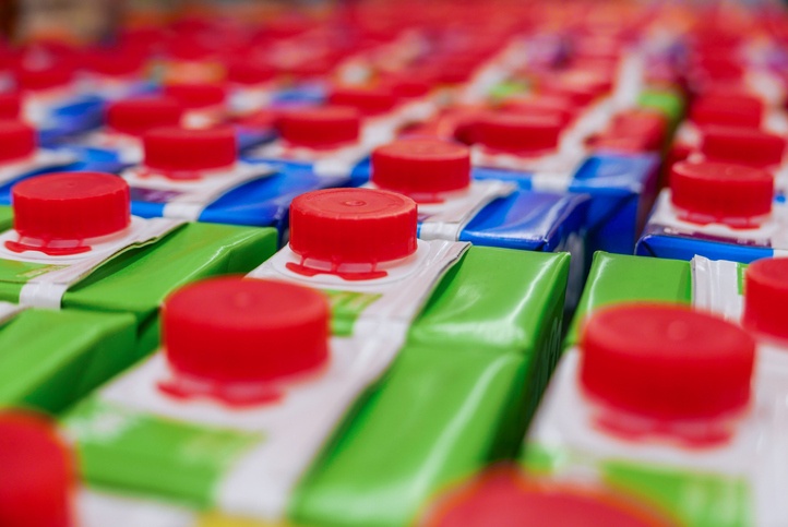 colorful Juice cartons with red screw cap in supermarket shelf.
