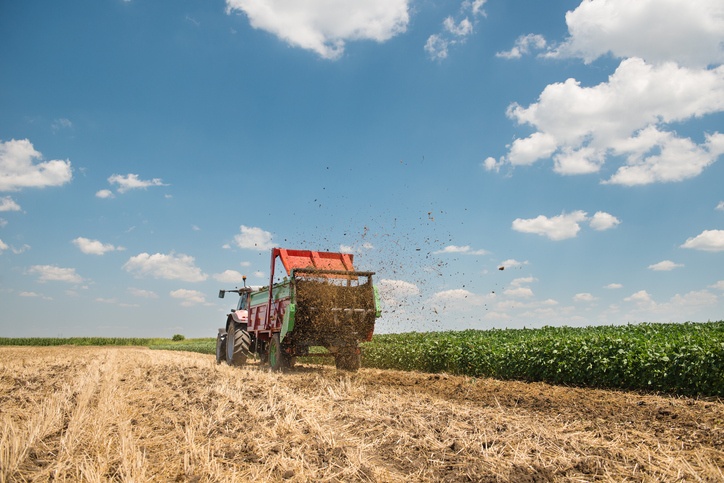 A tractor spreading manure on a field