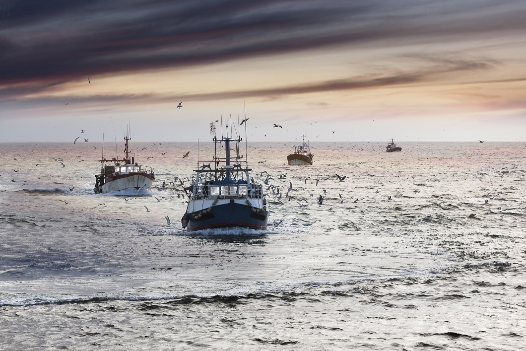 Homecoming: Tired fishermans ships approaching after a hard day, Le Guilvinec,Brittany, France